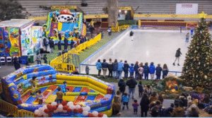 Vista panorámica de Moralpark 2024 con una pista de hielo donde varias personas patinan, un gran árbol y varias atracciones hinchables para niños.