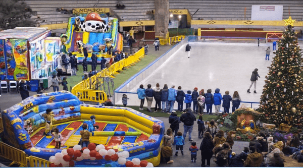 Vista panorámica de Moralpark 2024 con una pista de hielo donde varias personas patinan, un gran árbol y varias atracciones hinchables para niños.