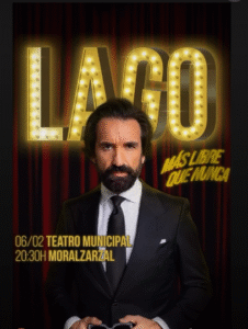 Cartel promocional del espectáculo de comedia “LAGO”, con el humorista de pie con traje oscuro sobre un fondo de cortinas rojas y luces doradas.
