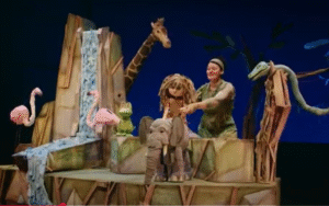 Escena del espectáculo infantil “Yo, Tarzán” con títeres de animales en una selva teatral.