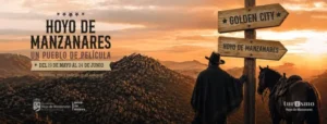 Cartel de Hoyo de Manzanares con un vaquero de espaldas junto a su caballo y un poste indicador de madera al atardecer.